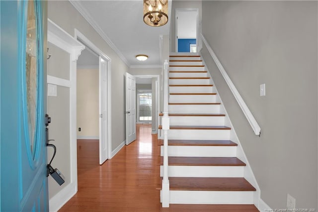 entryway featuring stairs, crown molding, baseboards, and wood finished floors