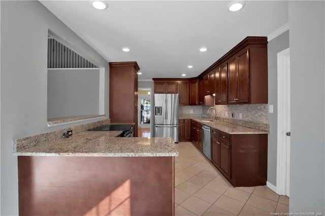 kitchen featuring a sink, light stone counters, stainless steel appliances, crown molding, and decorative backsplash