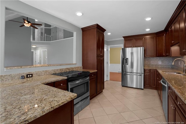 kitchen featuring light stone counters, light tile patterned floors, a sink, decorative backsplash, and stainless steel appliances