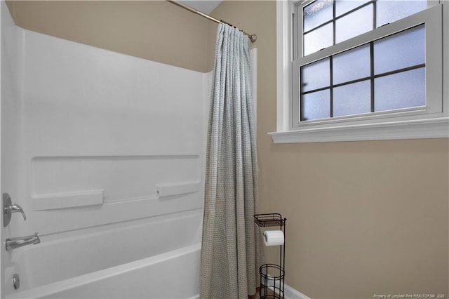 full bath featuring shower / bath combination with curtain and baseboards