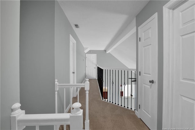 hallway featuring lofted ceiling with beams, visible vents, an upstairs landing, and carpet