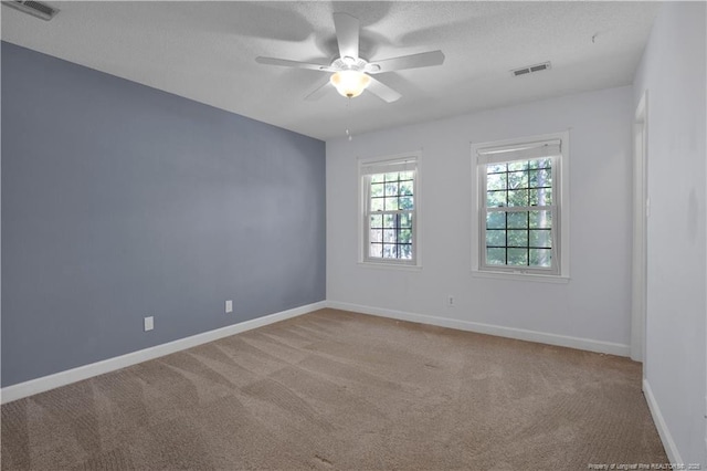 empty room featuring visible vents, a ceiling fan, baseboards, and carpet floors