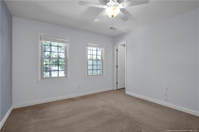 carpeted empty room featuring ceiling fan, a textured ceiling, and baseboards