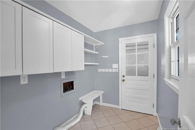 washroom featuring hookup for a washing machine, light tile patterned floors, cabinet space, and baseboards