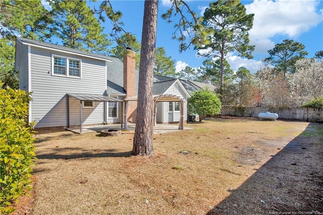 back of property with a patio, fence, and a chimney