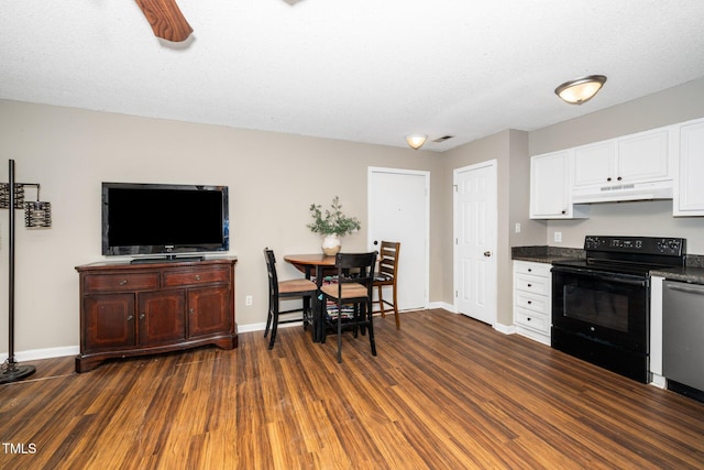 kitchen featuring dark countertops, under cabinet range hood, dark wood finished floors, dishwasher, and black electric range oven