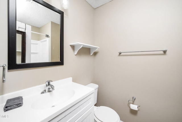 full bathroom with a textured ceiling, toilet, vanity, and walk in shower