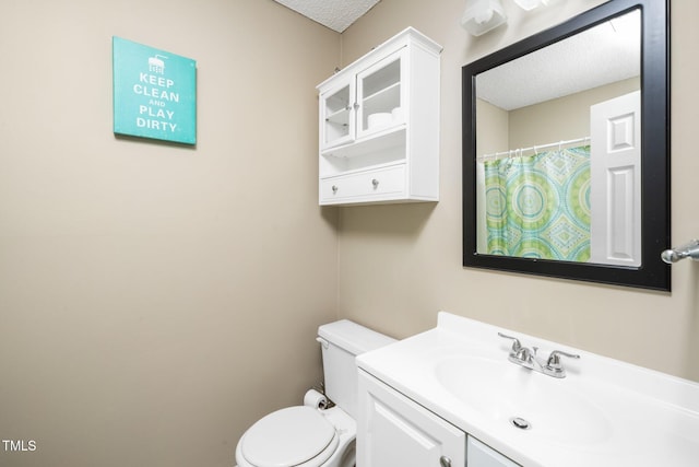 bathroom with curtained shower, toilet, vanity, and a textured ceiling