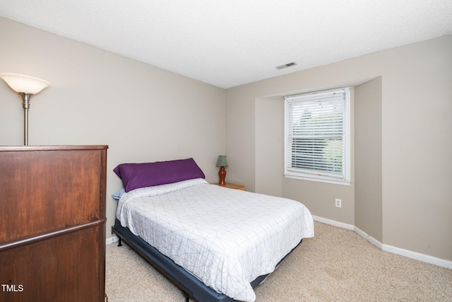 bedroom with baseboards, visible vents, carpet floors, and a textured ceiling