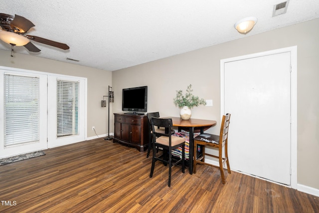 dining area featuring wood finished floors, visible vents, and a textured ceiling