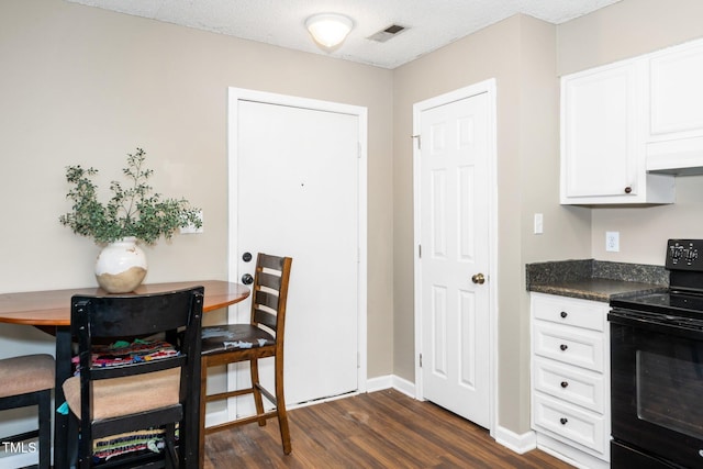 kitchen with custom exhaust hood, dark wood-type flooring, black range with electric stovetop, white cabinetry, and dark countertops