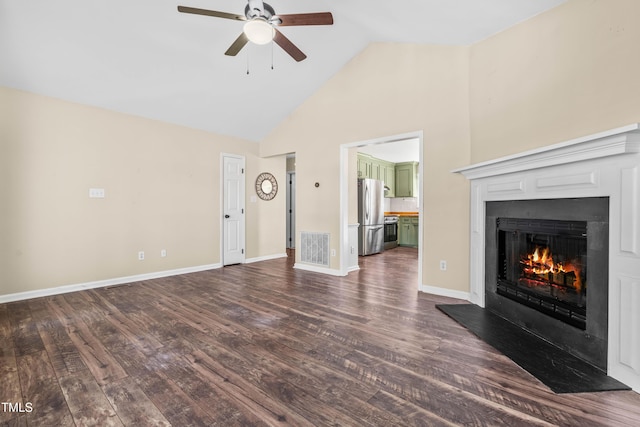 unfurnished living room featuring visible vents, baseboards, a lit fireplace, and dark wood finished floors