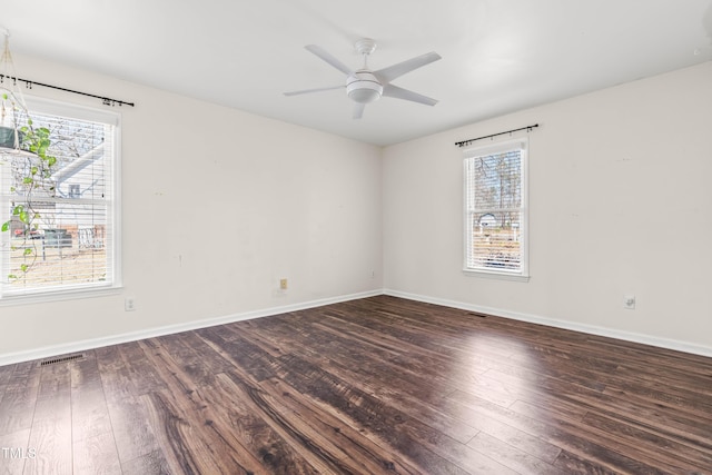 unfurnished room with a wealth of natural light, visible vents, and wood-type flooring