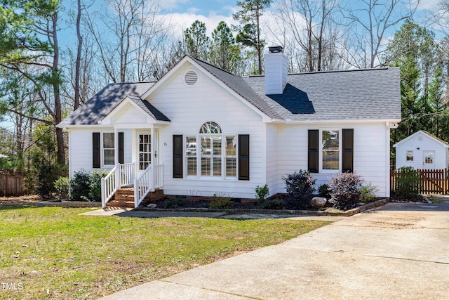 ranch-style home with fence, roof with shingles, a front yard, a chimney, and crawl space