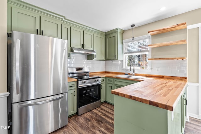 kitchen featuring butcher block countertops, appliances with stainless steel finishes, green cabinets, and under cabinet range hood