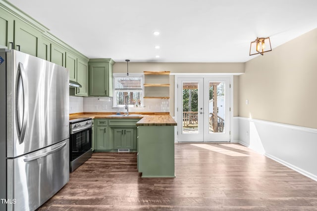 kitchen with a sink, dark wood-type flooring, appliances with stainless steel finishes, wood counters, and green cabinets