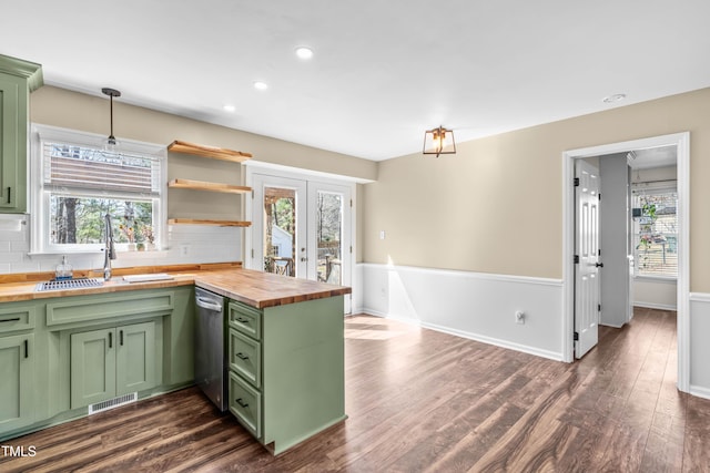 kitchen featuring backsplash, wood counters, green cabinets, and a sink