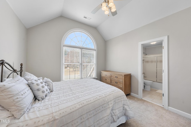 bedroom with visible vents, baseboards, lofted ceiling, light carpet, and ensuite bathroom