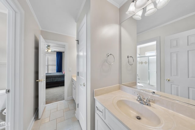 ensuite bathroom featuring an inviting chandelier, crown molding, vanity, and baseboards