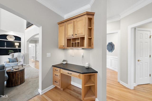 interior space featuring open shelves, crown molding, arched walkways, and light wood finished floors