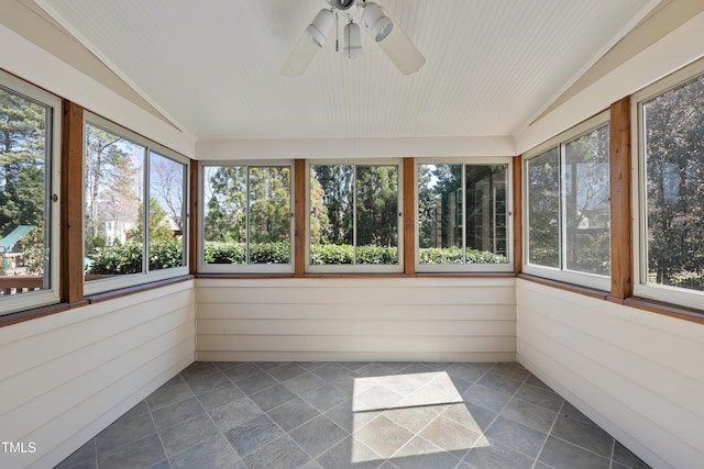 unfurnished sunroom featuring plenty of natural light, a ceiling fan, and vaulted ceiling