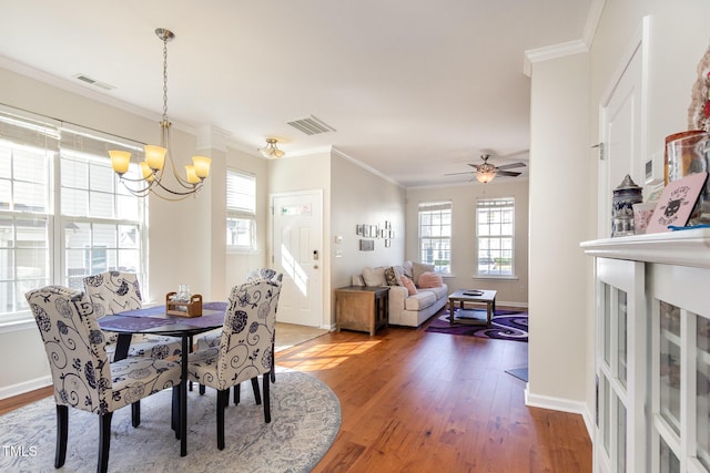 dining space featuring crown molding, wood finished floors, and visible vents