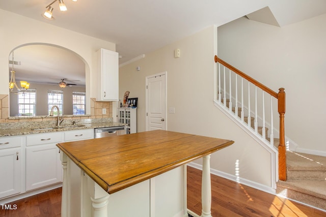 kitchen with decorative backsplash, dark wood-type flooring, white cabinetry, and a sink