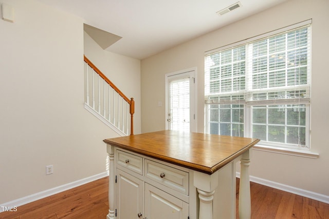 kitchen featuring light wood-type flooring, visible vents, baseboards, and white cabinets