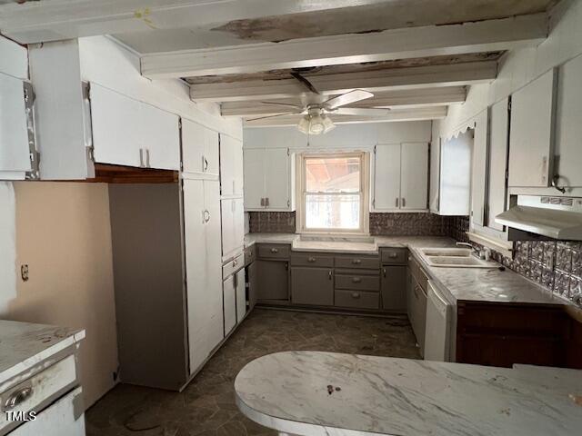 kitchen with beamed ceiling, tasteful backsplash, white dishwasher, and under cabinet range hood