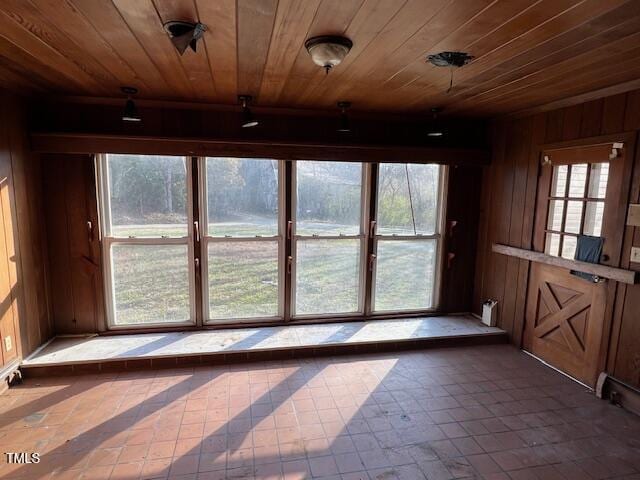 unfurnished sunroom featuring wooden ceiling