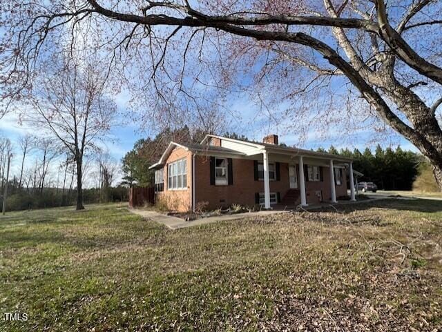 view of front of house featuring a front yard, a porch, and a chimney