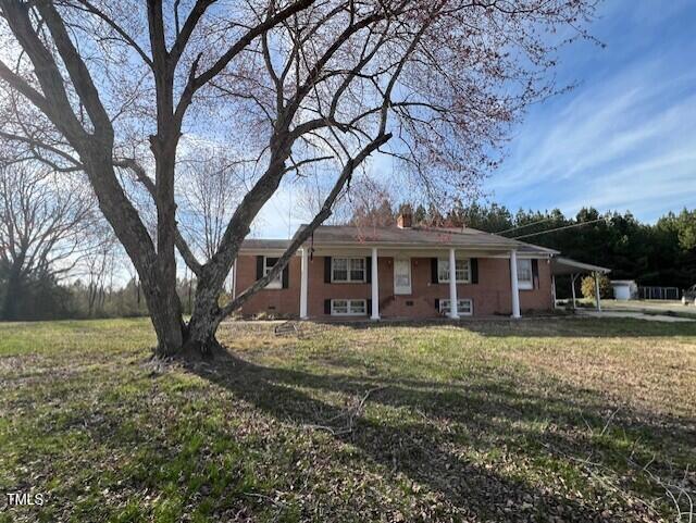 ranch-style home with a front yard and a carport