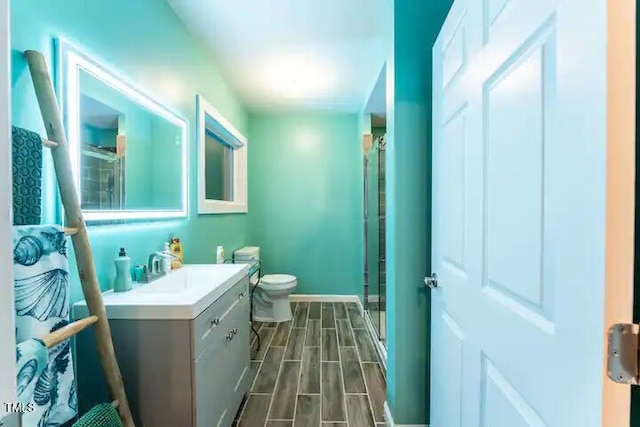 bathroom with vanity, a shower stall, toilet, and wood tiled floor