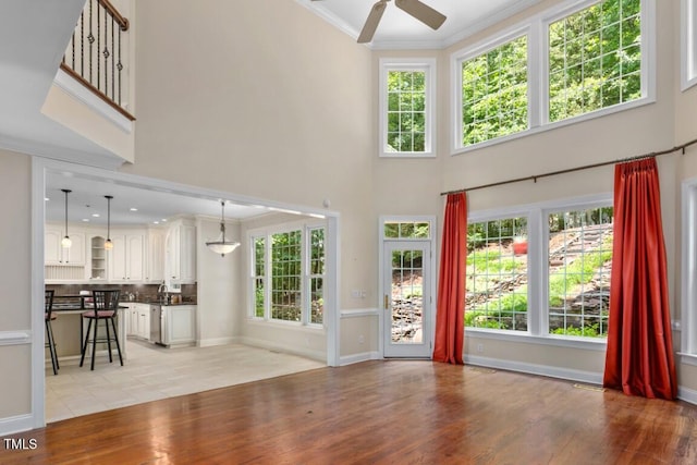 405 Silver Creek Trl, Chapel Hill, NC 27514 - unfurnished living room with a ceiling fan, light wood-style flooring, a towering ceiling, and ornamental molding