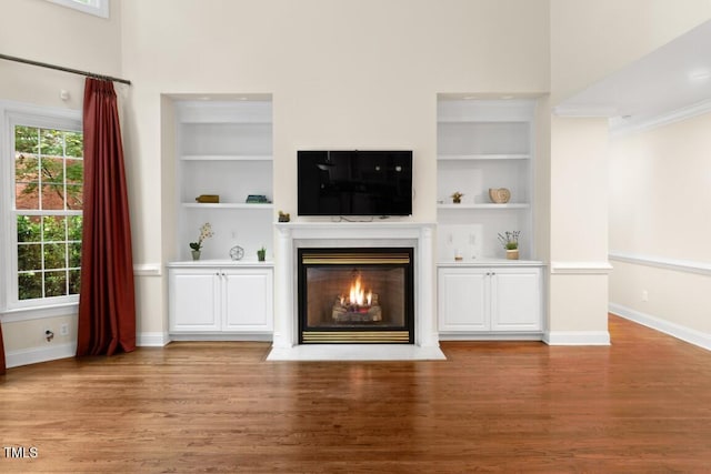 405 Silver Creek Trl, Chapel Hill, NC 27514 - unfurnished living room with built in shelves, wood finished floors, a fireplace with flush hearth, and crown molding