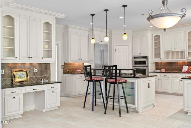 405 Silver Creek Trl, Chapel Hill, NC 27514 - kitchen featuring appliances with stainless steel finishes, backsplash, a kitchen bar, dark countertops, and hanging light fixtures