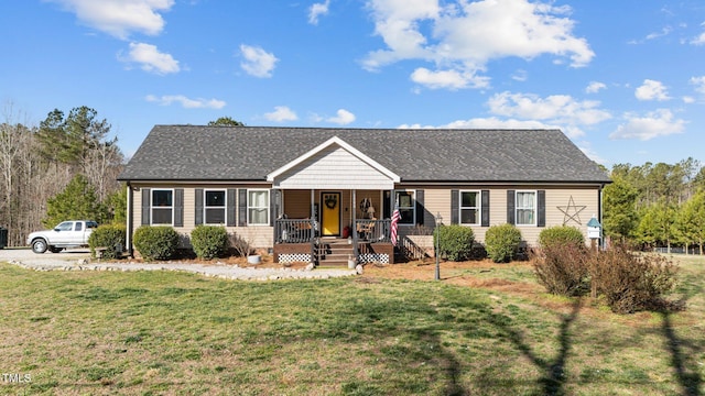 single story home featuring covered porch, a front lawn, and roof with shingles