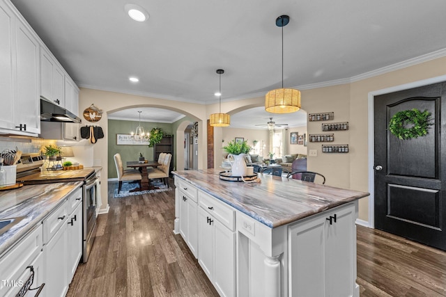 kitchen featuring under cabinet range hood, arched walkways, white cabinets, and electric stove