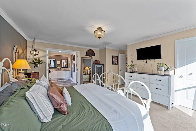 bedroom with ornamental molding, ensuite bathroom, and light carpet