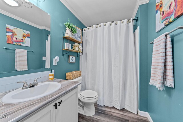 full bath with vanity, a shower with shower curtain, wood finished floors, crown molding, and toilet