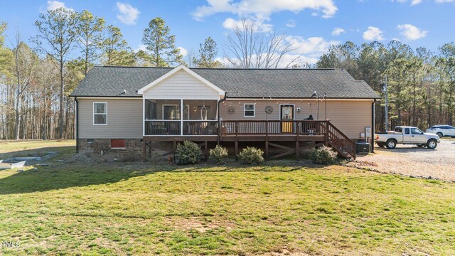 back of house featuring a lawn, a deck, a sunroom, stairway, and a shingled roof