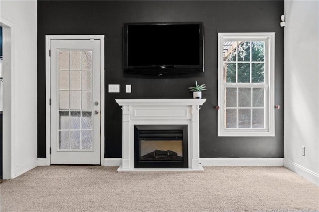 unfurnished living room with carpet flooring, a fireplace, and baseboards