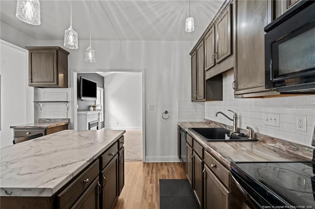 kitchen featuring hanging light fixtures, black appliances, dark brown cabinetry, and a sink