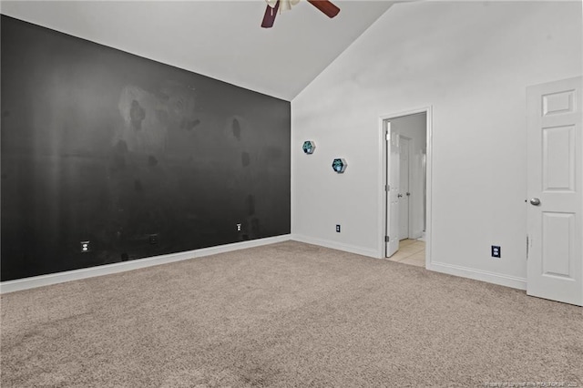 carpeted empty room featuring baseboards, high vaulted ceiling, and a ceiling fan