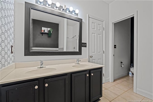 full bathroom with tile patterned flooring, double vanity, toilet, and a sink