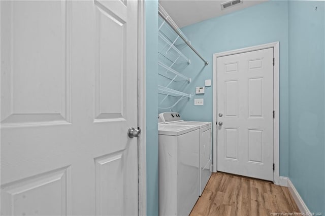 laundry room with visible vents, baseboards, washing machine and dryer, laundry area, and light wood-style floors