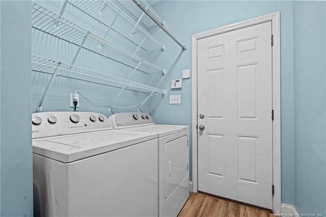 laundry area with wood finished floors, laundry area, and washing machine and clothes dryer