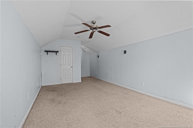 additional living space featuring baseboards, visible vents, carpet floors, lofted ceiling, and ceiling fan