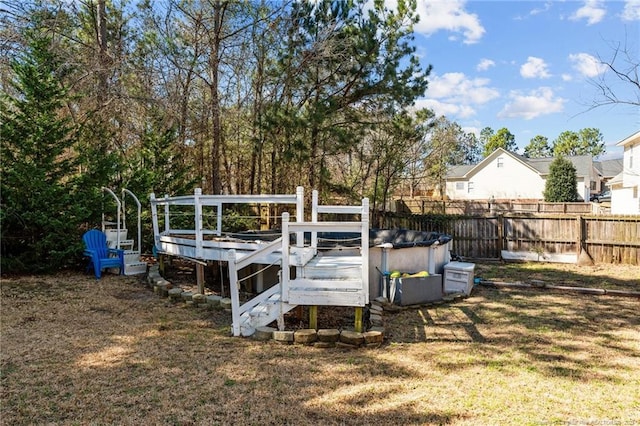 view of yard with a wooden deck, a fenced in pool, and fence