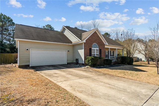 ranch-style house featuring driveway, fence, a front yard, an attached garage, and brick siding